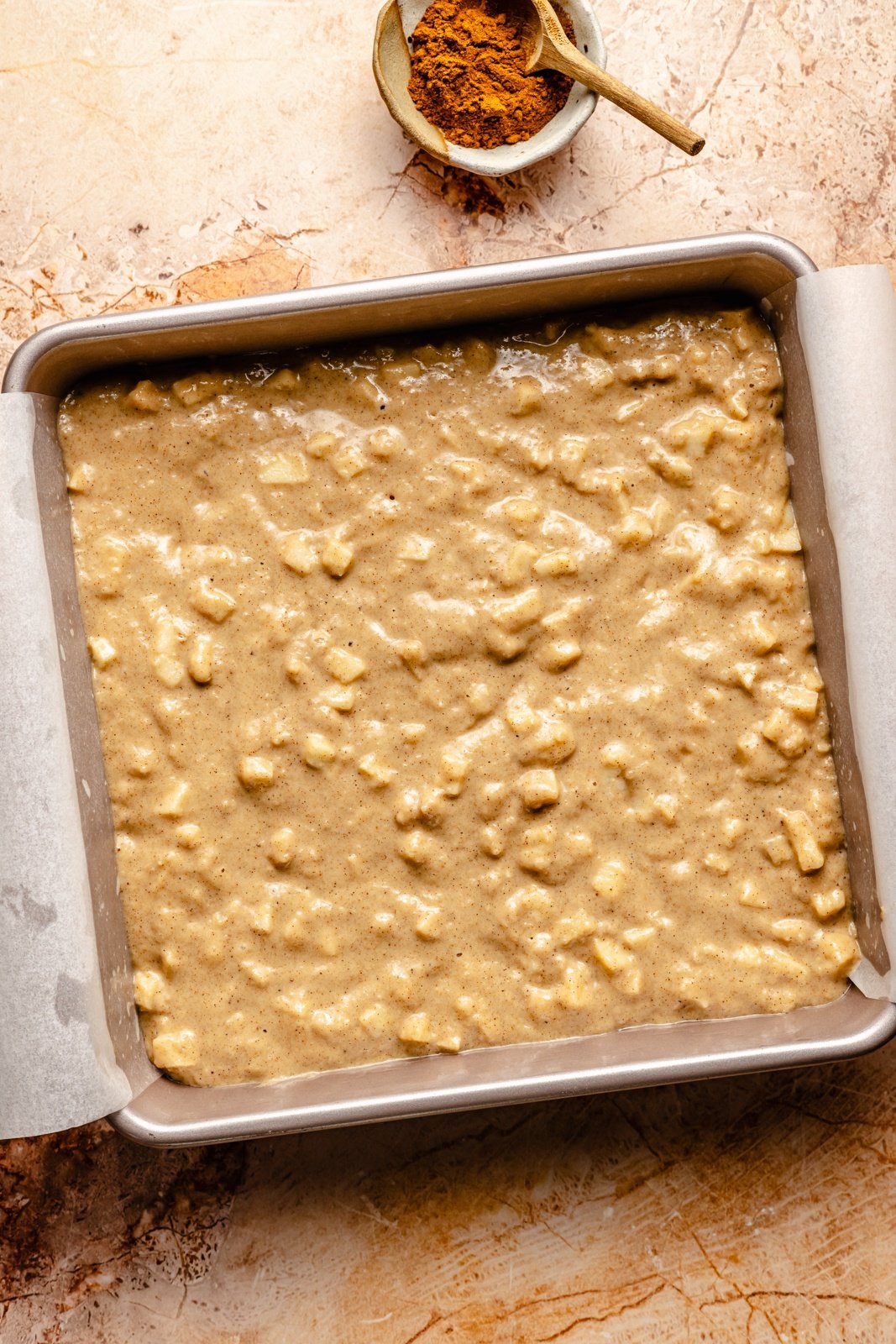 unbaked apple cake in a square pan