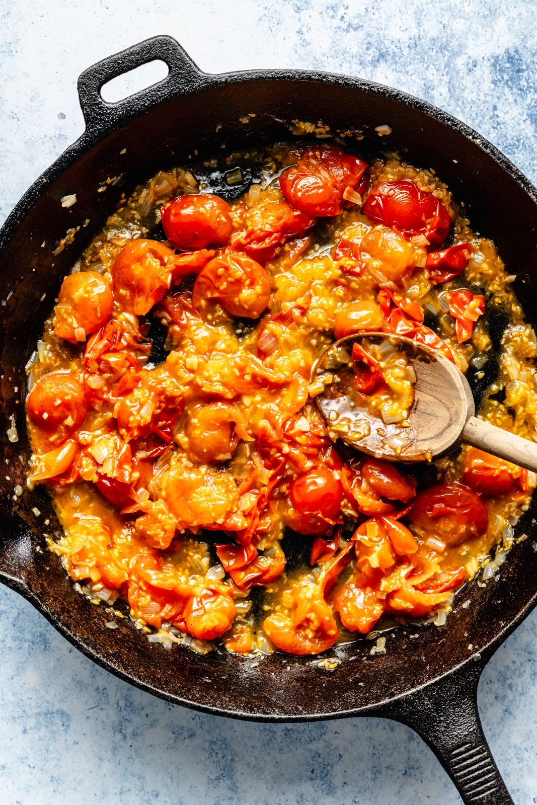 cooking tomatoes for a pepperoni white bean dip in a skillet