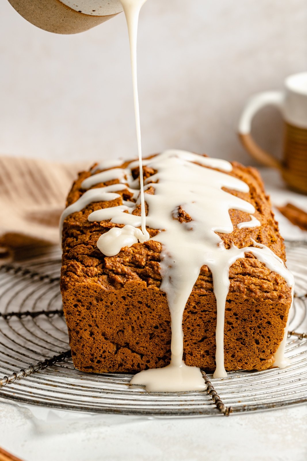 pouring a glaze onto the best healthy pumpkin bread