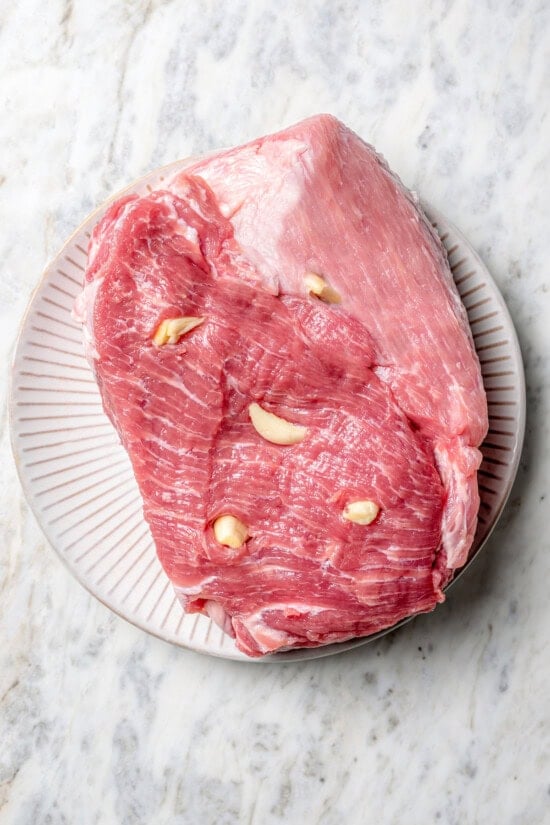 Pressing garlic into pork