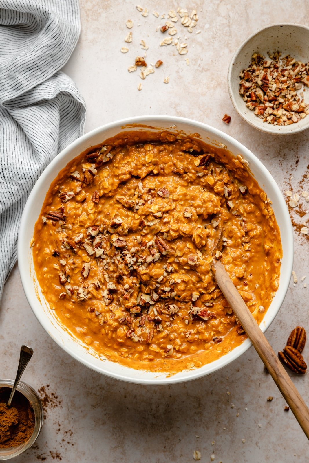 mixing ingredients for a pumpkin pie baked oatmeal in a bowl