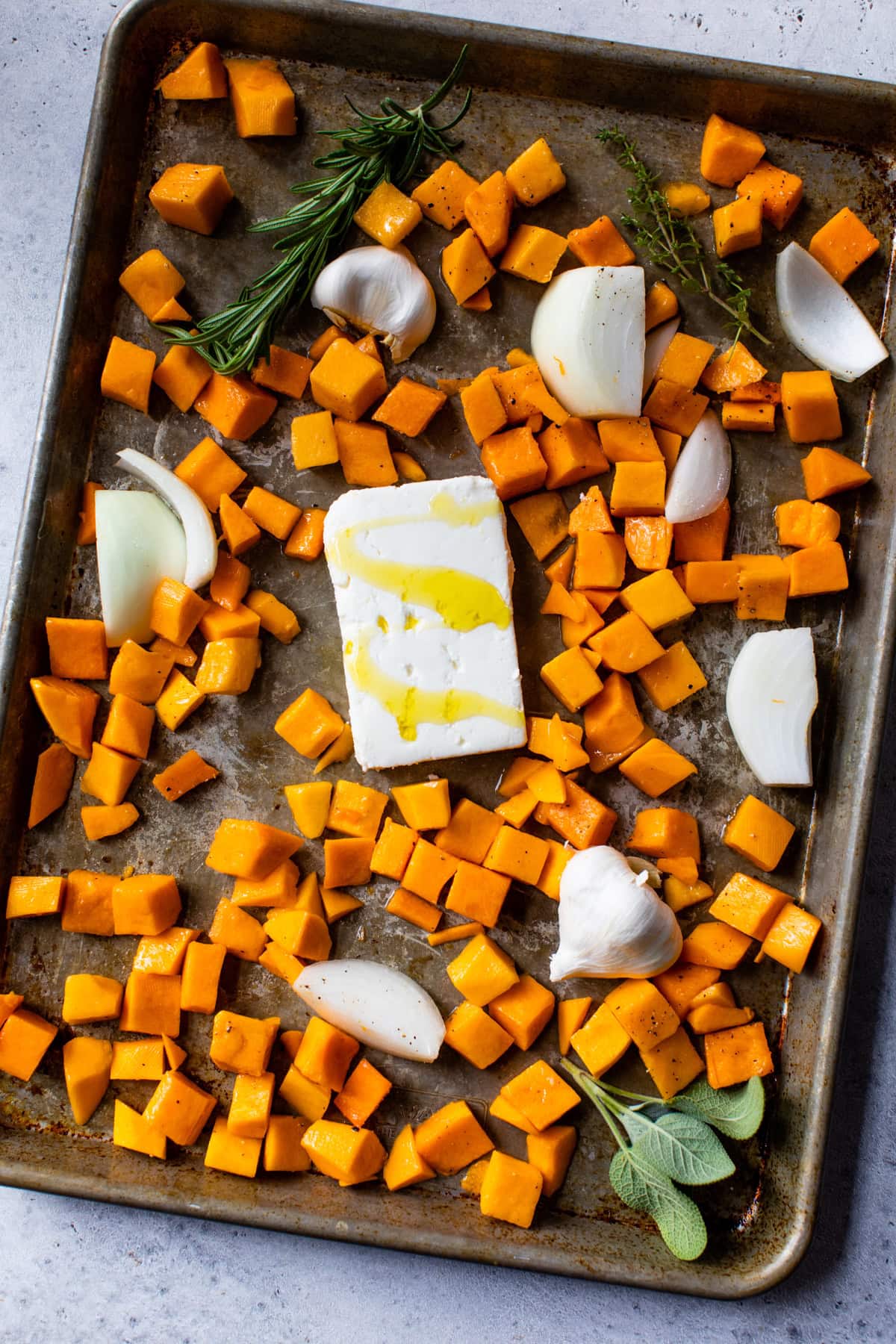 Sheet pan with butternut squash feta cheese, onions and onions.