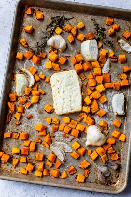 Sheet pan with butternut squash feta cheese, onions and onions.