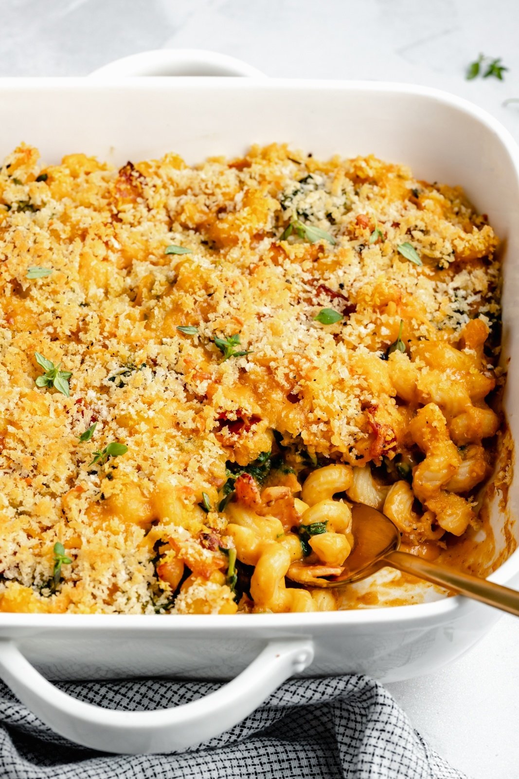 pumpkin mac and cheese in a casserole dish with a spoon
