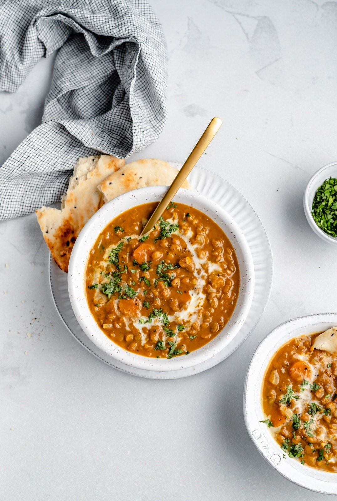 bowl of vegan curried pumpkin lentil soup with naan