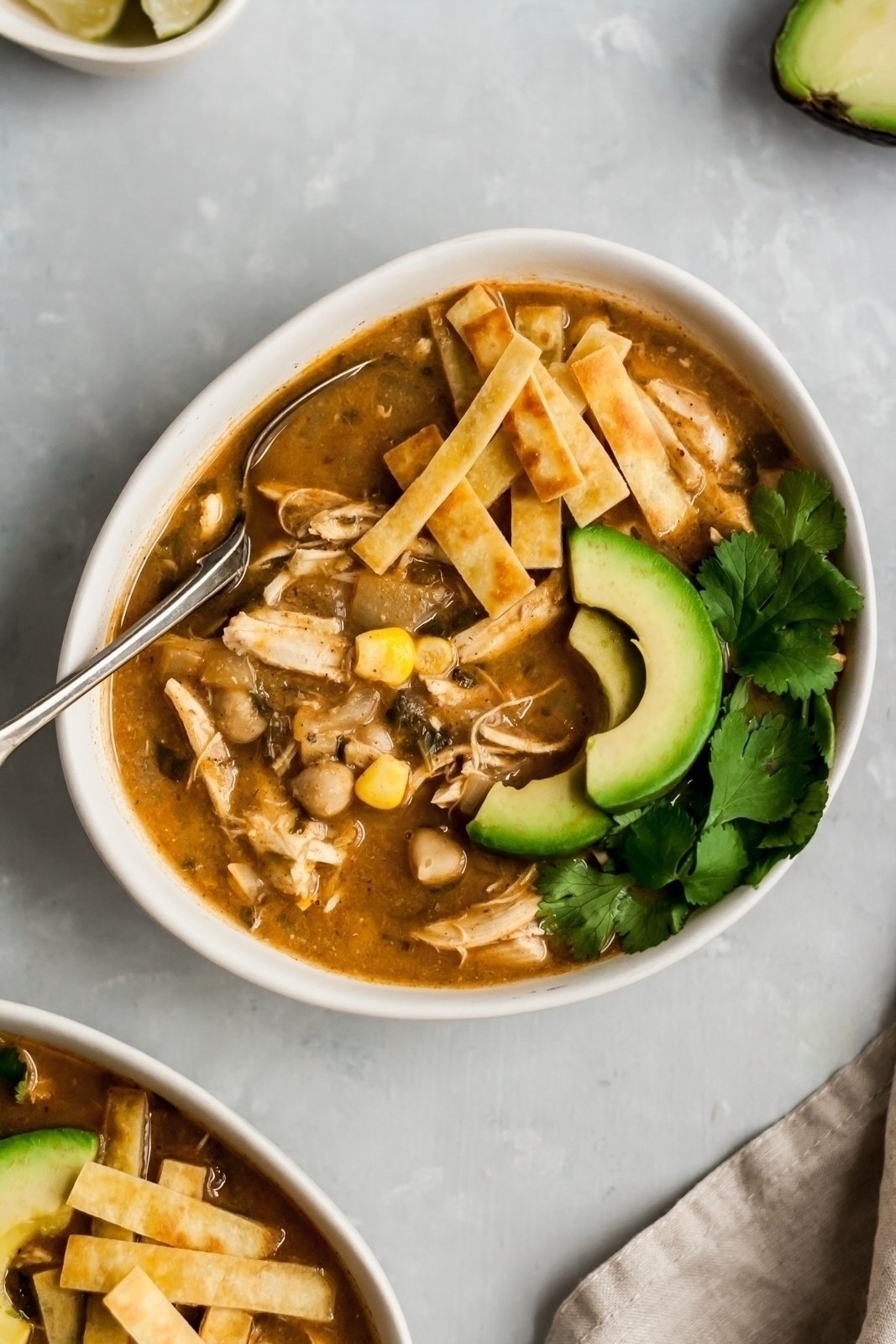 easy white chicken chili in a bowl topped with tortilla strips and avocado slices