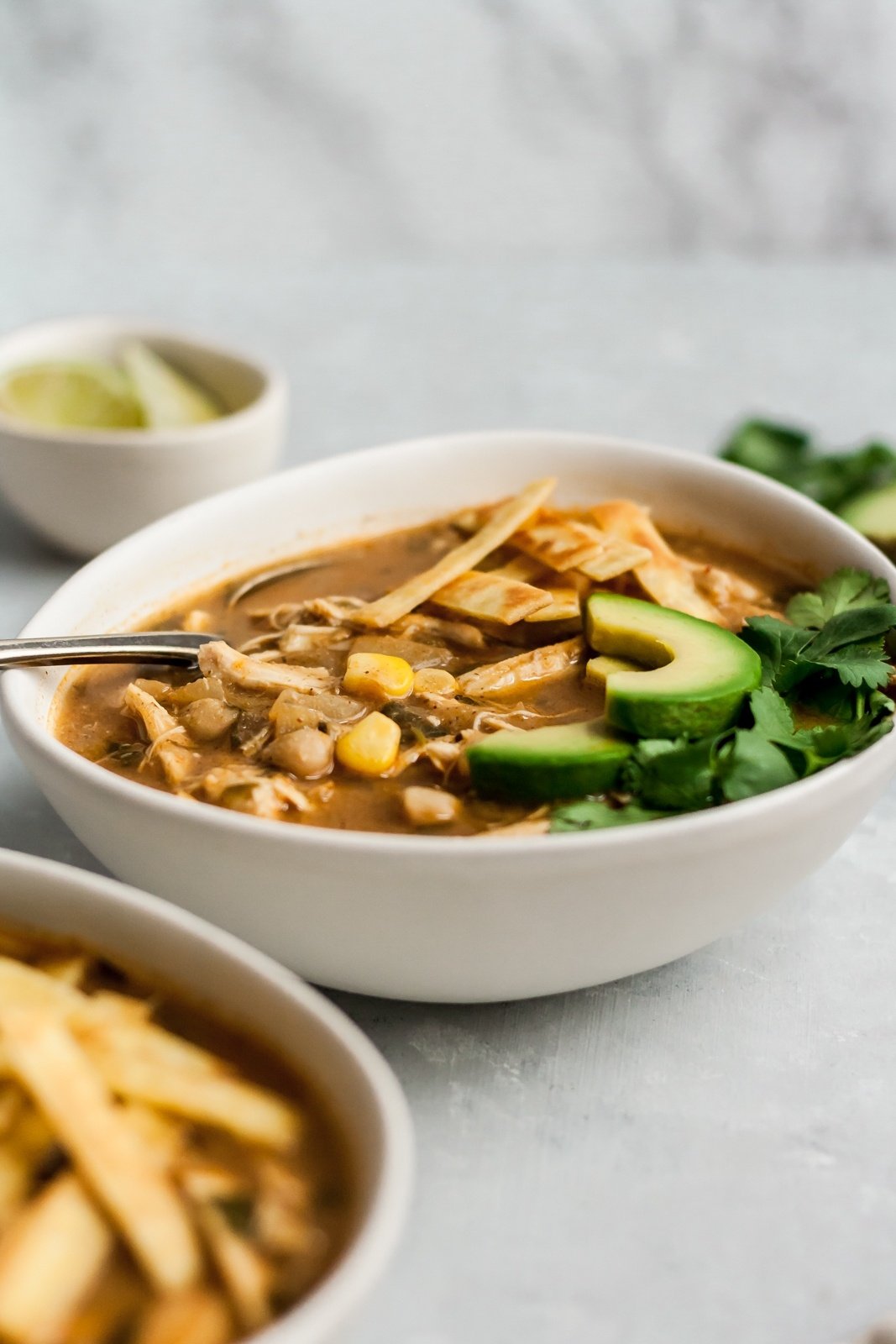 healthy white chicken chili in a bowl topped with avocado slices