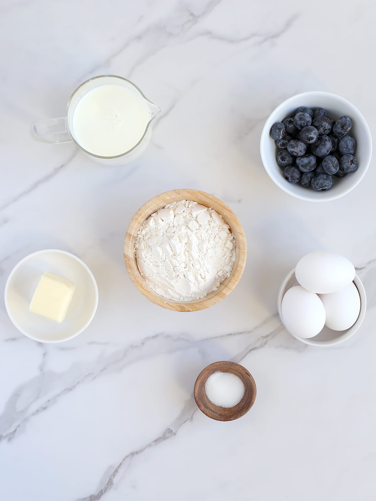 Ingredients needed to make dutch baby pancakes with blueberries.