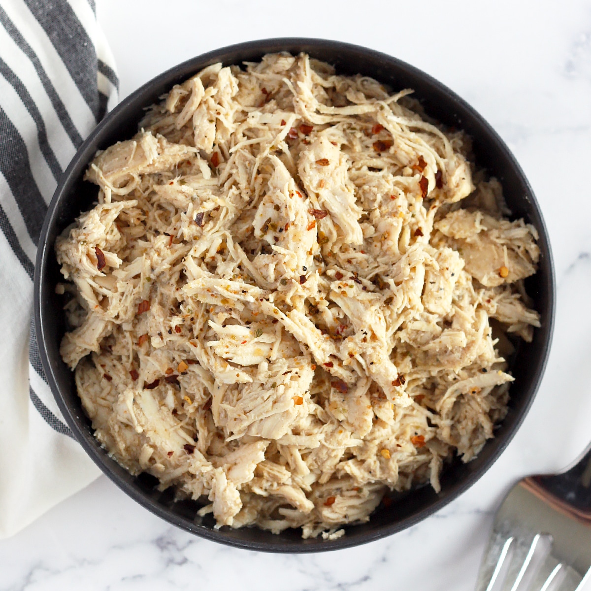 a bowl of shredded chicken with spices like the version at cafe rio restaurant