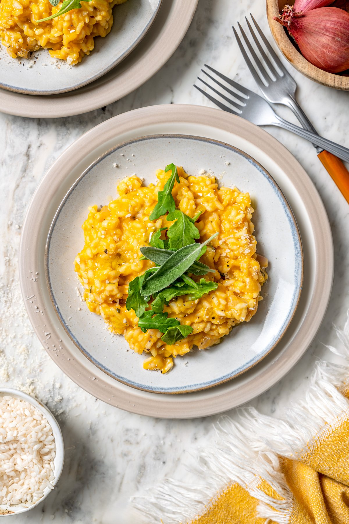 Butternut squash risotto is creamy, delicious and satisfying! It takes a little time, but it’s still easy to make—and absolutely worth it! Plate of butternut squash risotto with arugula and sage