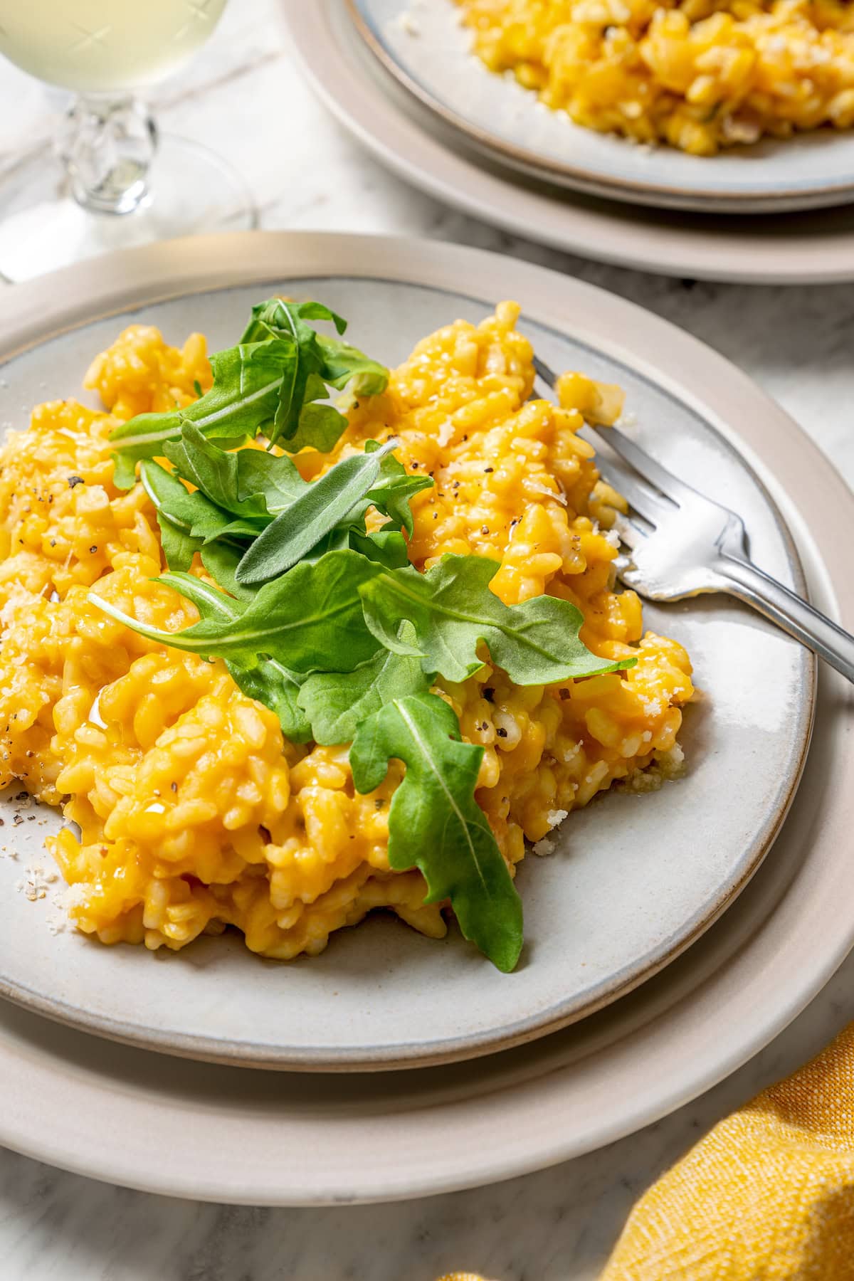 Butternut squash risotto is creamy, delicious and satisfying! It takes a little time, but it’s still easy to make—and absolutely worth it! Plate of butternut squash risotto with fork