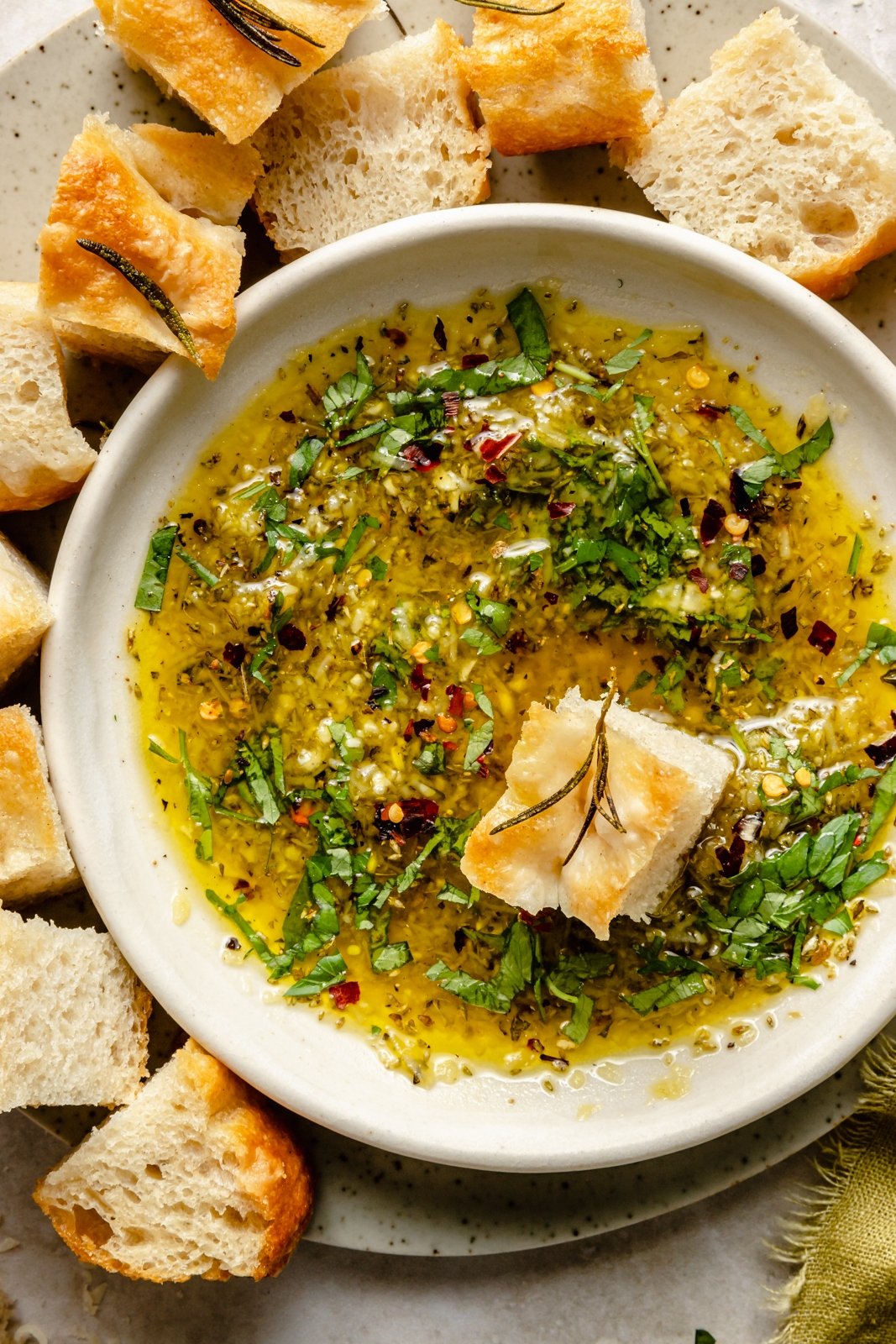 olive oil dip in a bowl with a piece of bread