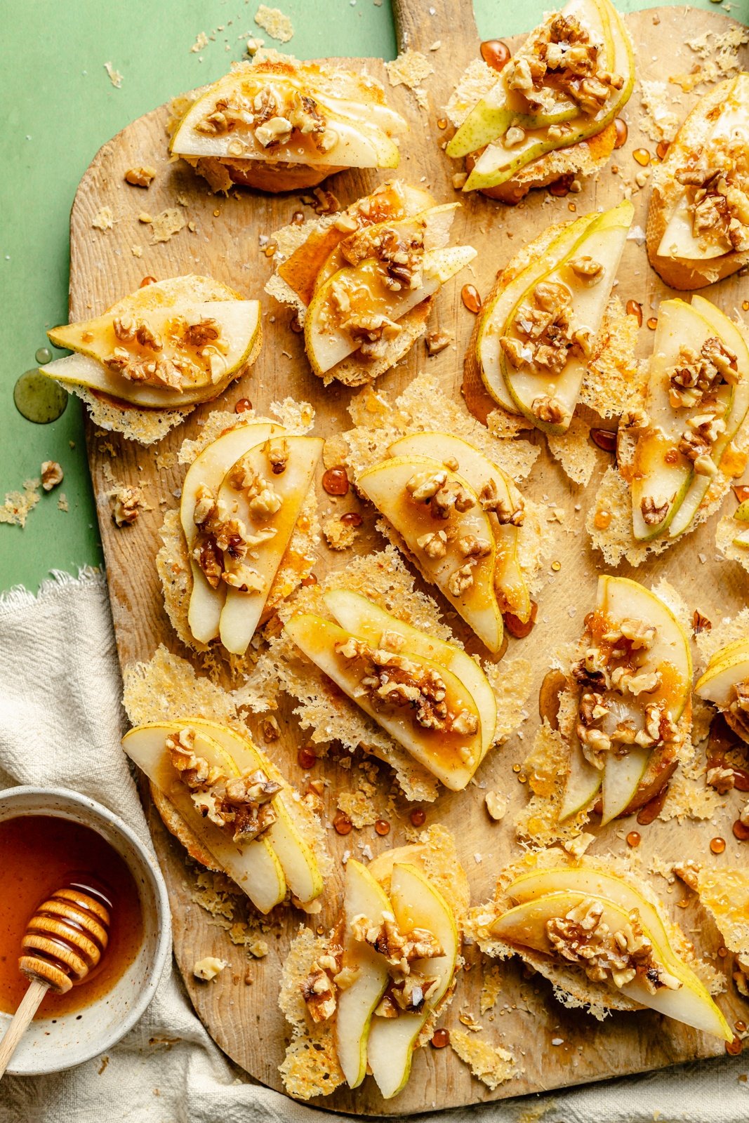 parmesan pear crostini with walnuts and honey on a cutting board