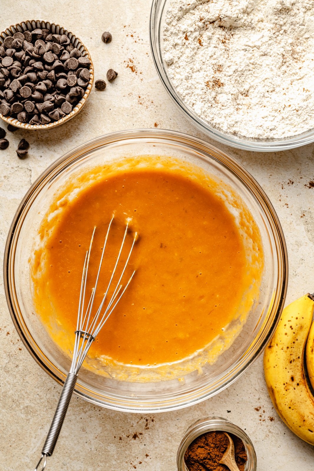 mixing banana pumpkin chocolate chip muffin batter in a bowl