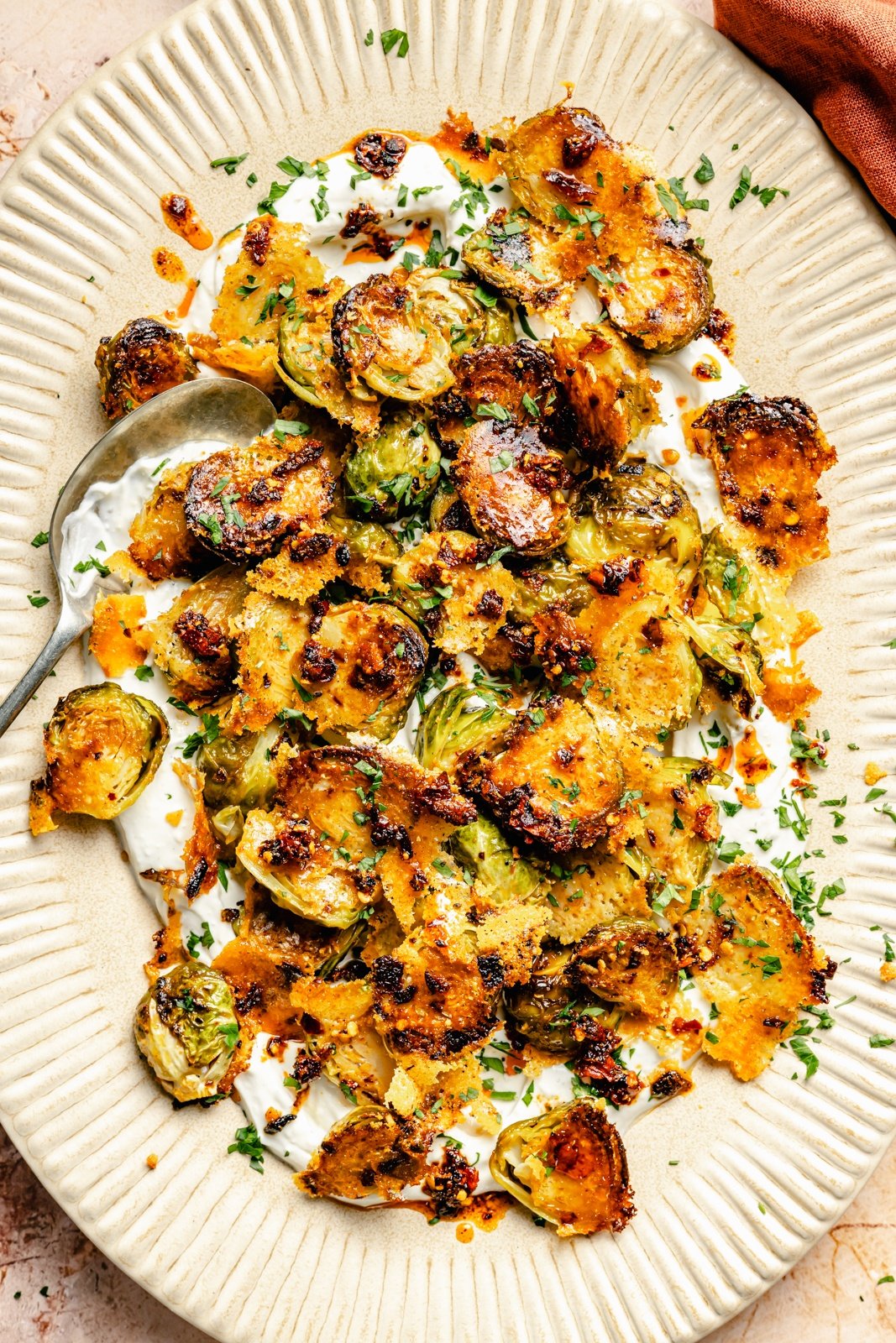 spicy parmesan roasted brussels sprouts on a platter with sauce