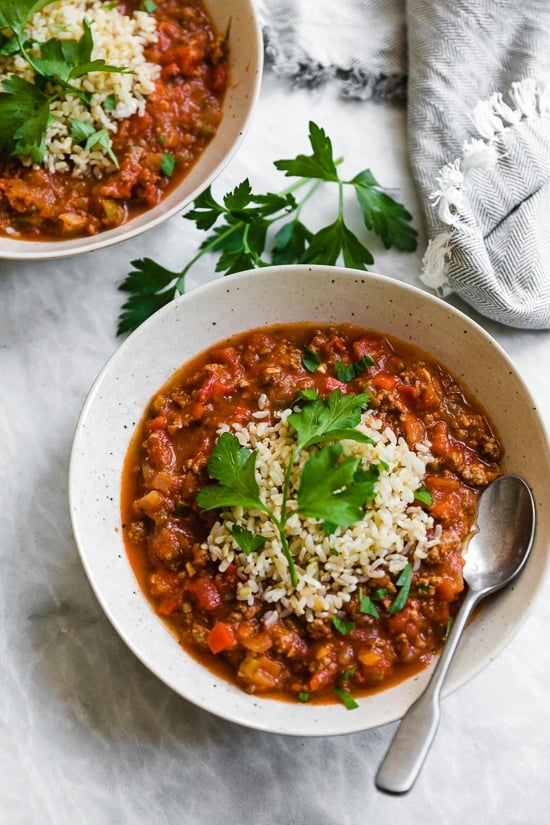 This easy stuffed pepper soup has bell peppers, ground beef, tomatoes, and rice in a hearty bowl of soup. Stovetop and Instant Pot options! Bowl of hearty stuffed pepper soup with rice