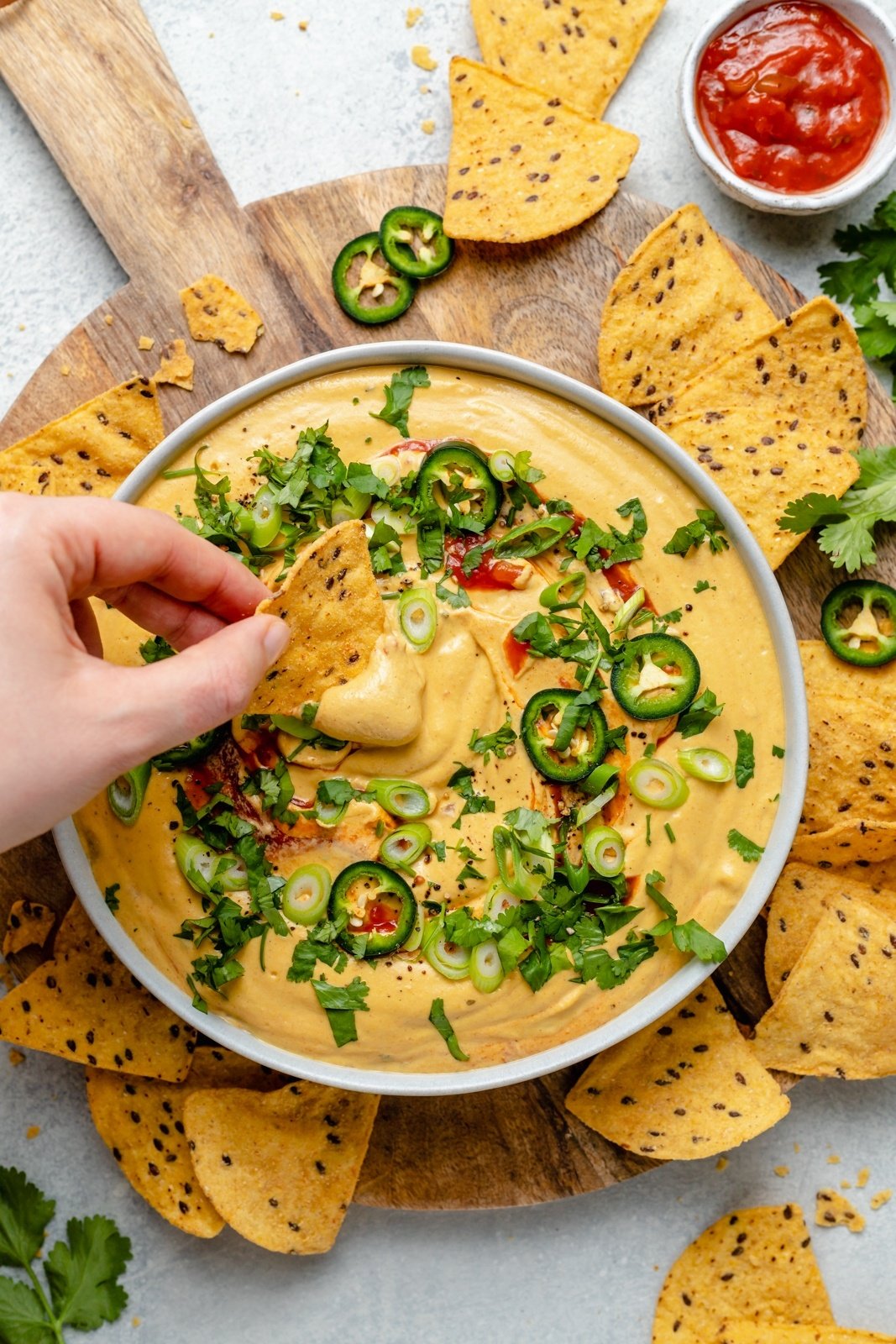 Over 20 of the best Thanksgiving appetizers that are guaranteed to impress family and friends! You'll find unique crostini recipes, savory handhelds, delicious dips, and more for your Thanksgiving menu or to bring as a guest this holiday season. These easy Thanksgiving apps might just outshine the turkey! dipping a chip into a bowl of vegan butternut squash queso
