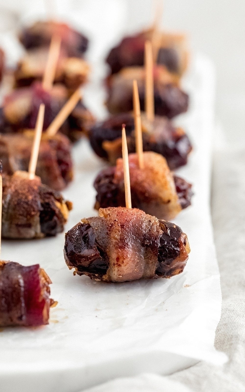 bacon wrapped dates on parchment paper