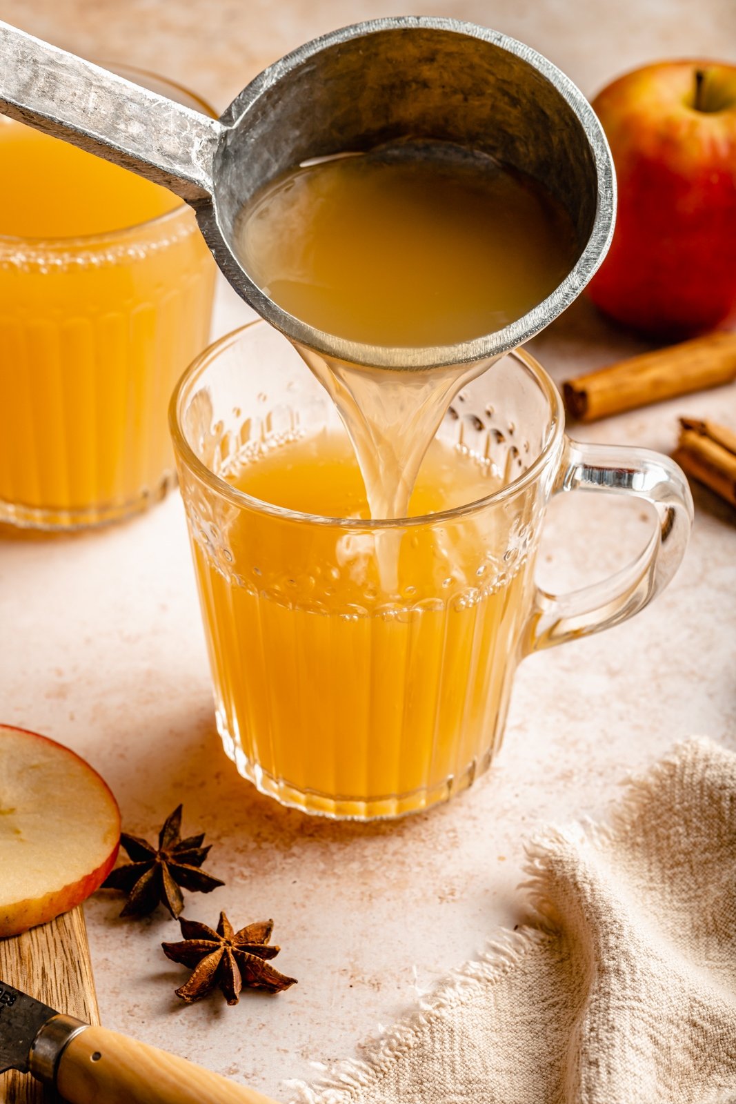 pouring an apple cider hot toddy into a glass