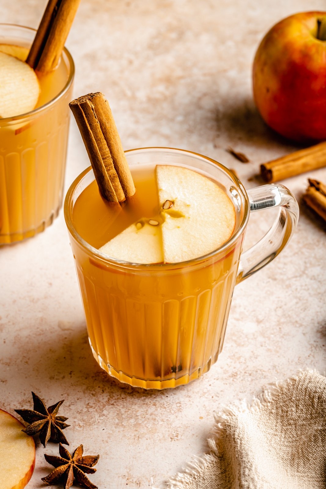 apple hot toddy in a glass with a cinnamon stick