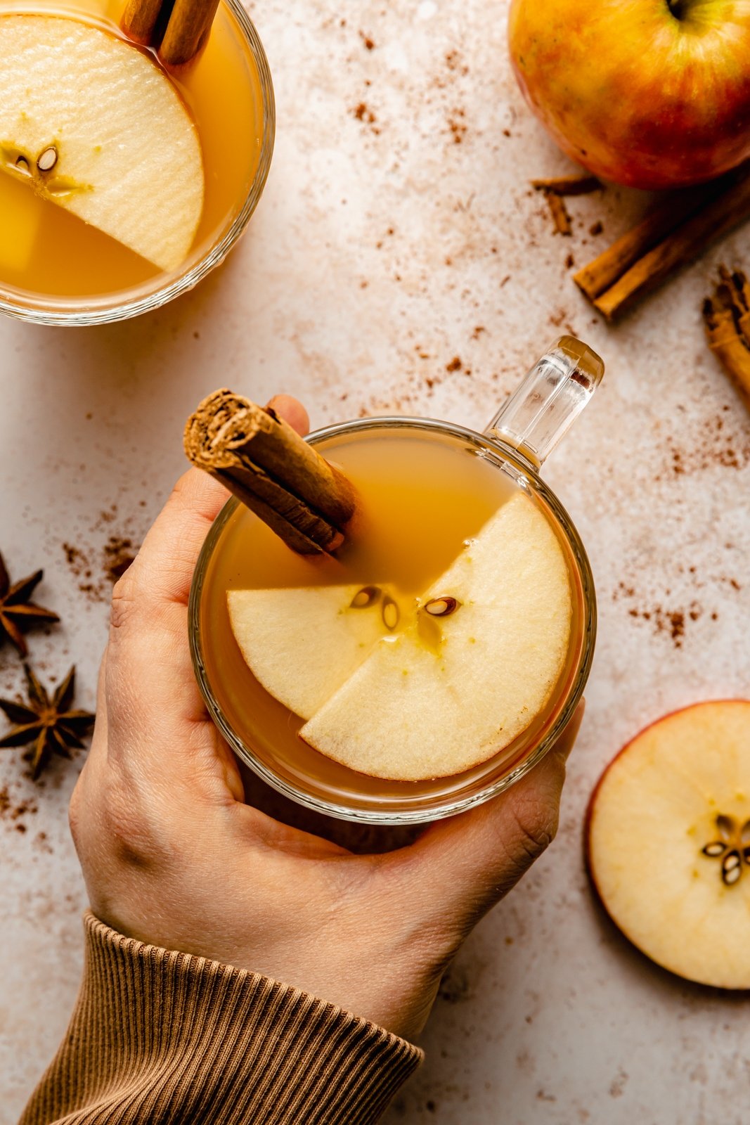 hand holding an apple cider hot toddy