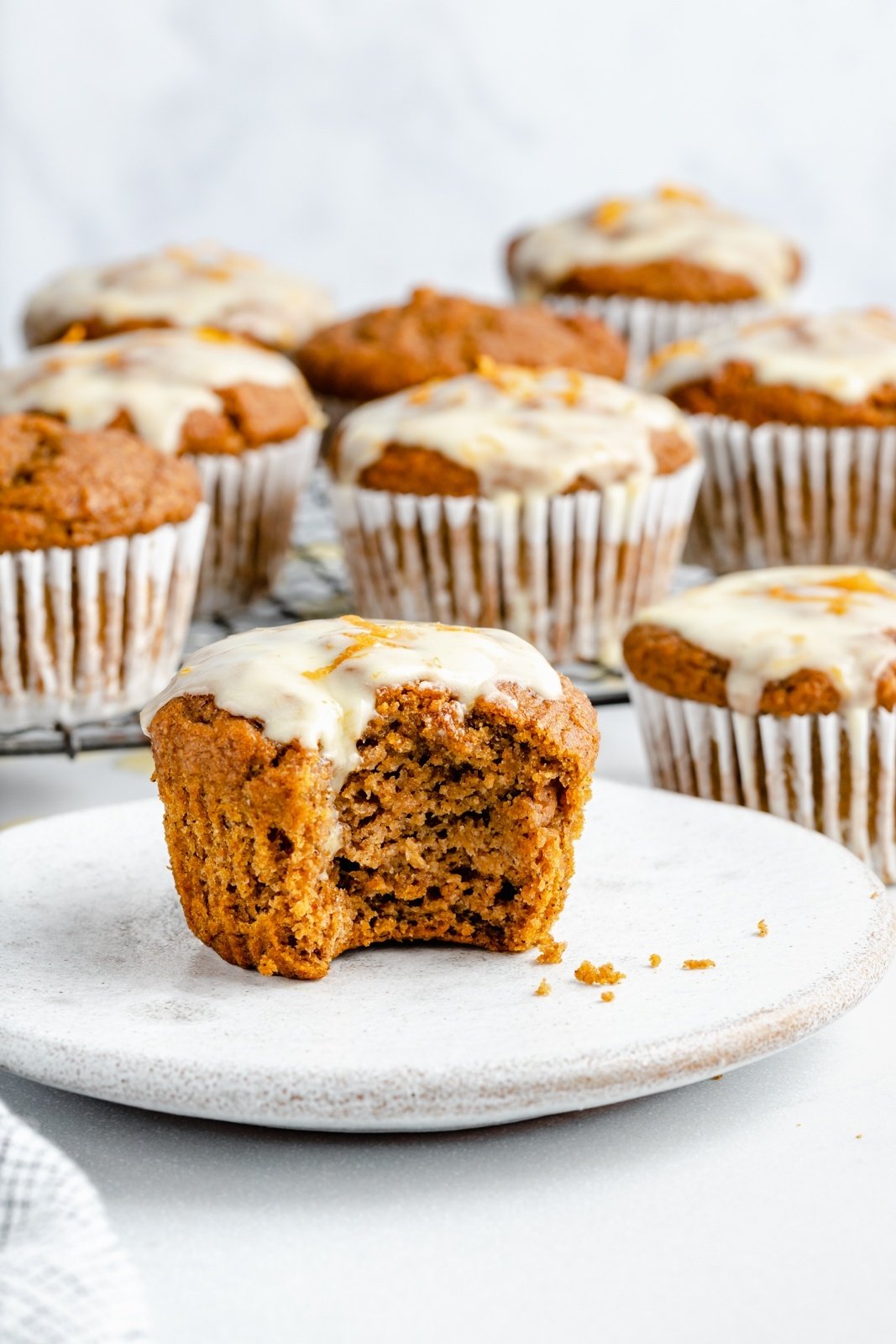 orange pumpkin muffin on a plate with a bite taken out
