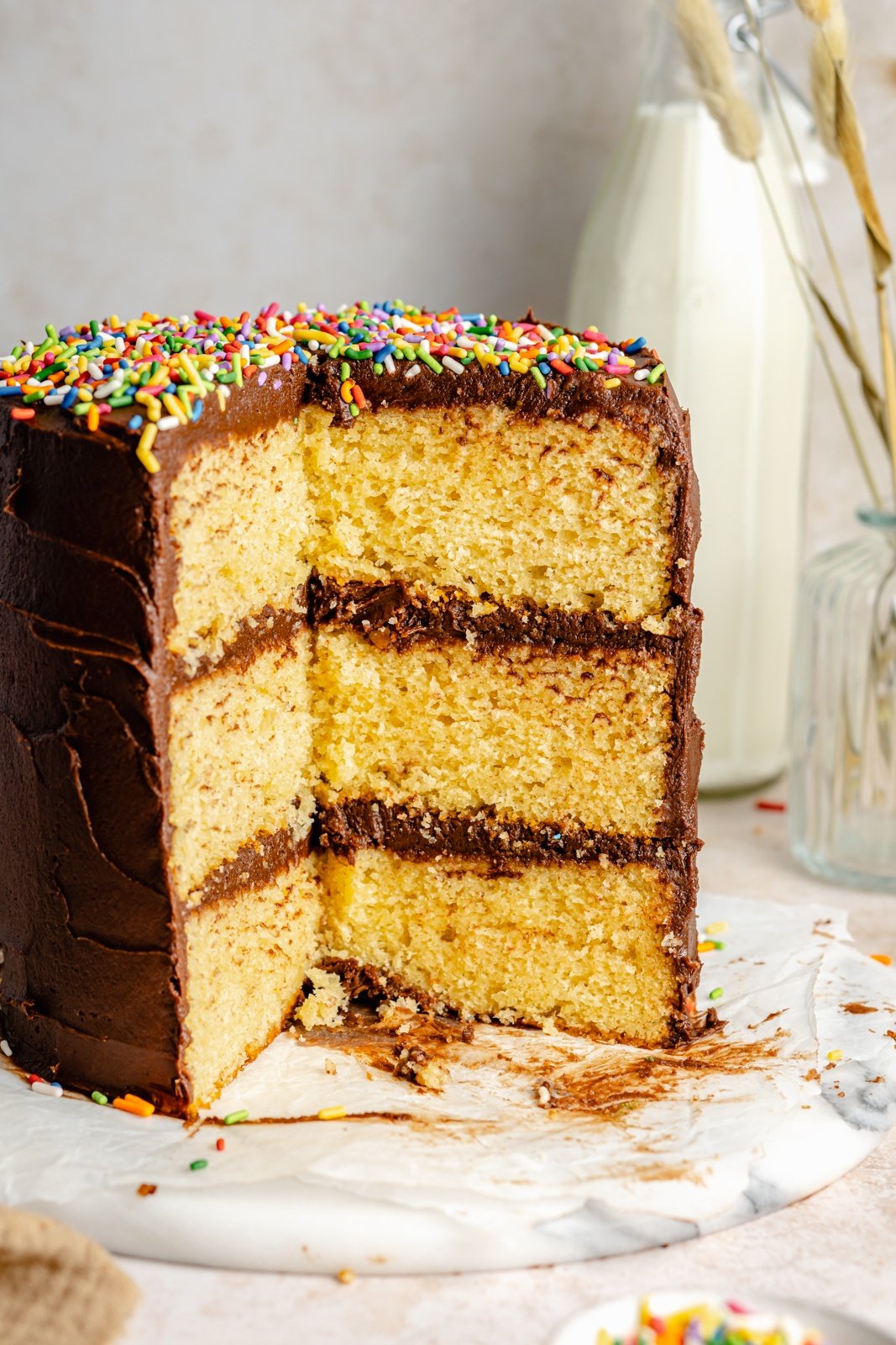 yellow cake with chocolate buttercream frosting with slices taken out