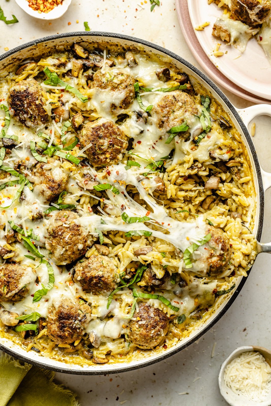 pesto orzo with chicken meatballs in a skillet