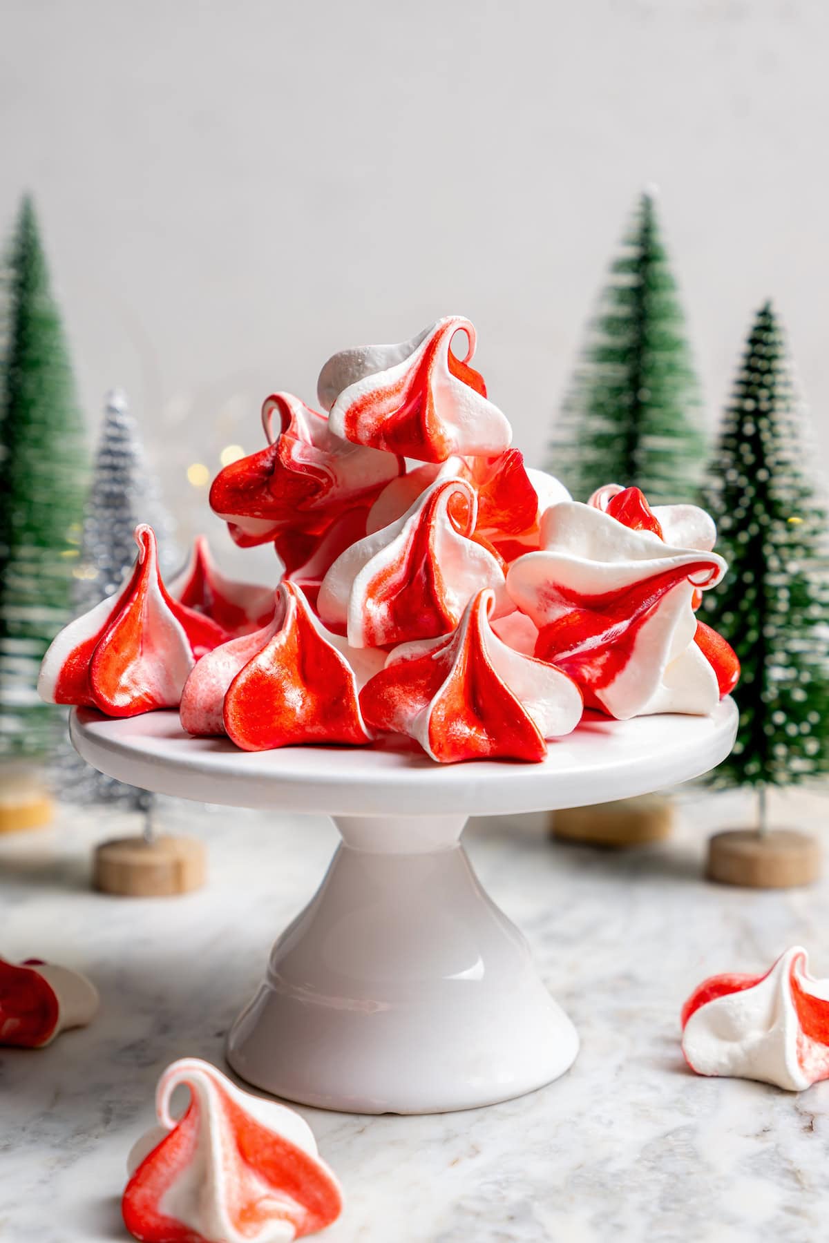 Light and airy peppermint meringues are the perfect addition to any holiday cookie tray! They're surprisingly easy to make and always a hit. Peppermint meringues on cake stand