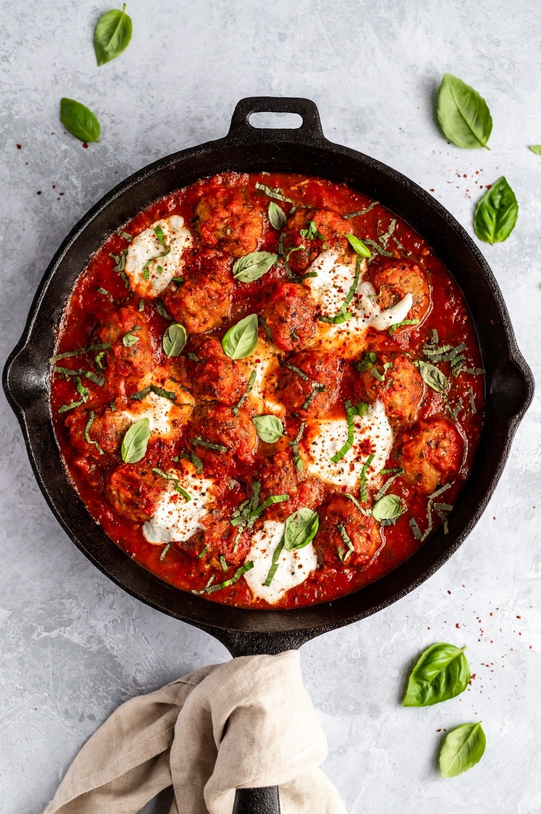 turkey meatballs in a skillet with tomato basil sauce and burrata