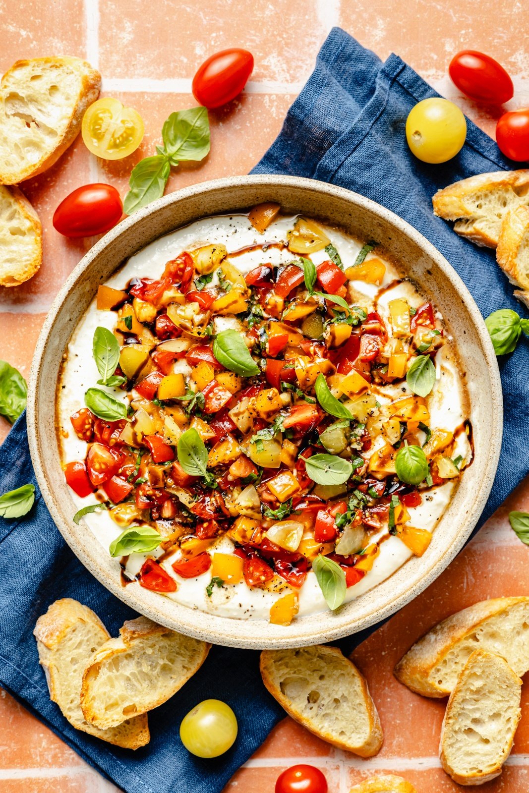 whipped feta bruschetta dip in a bowl next to crostini