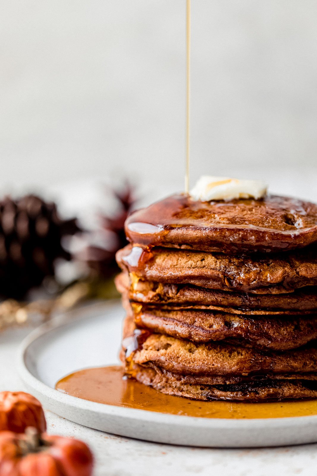 stack of healthy gingerbread pancakes in a plate with syrup and butter