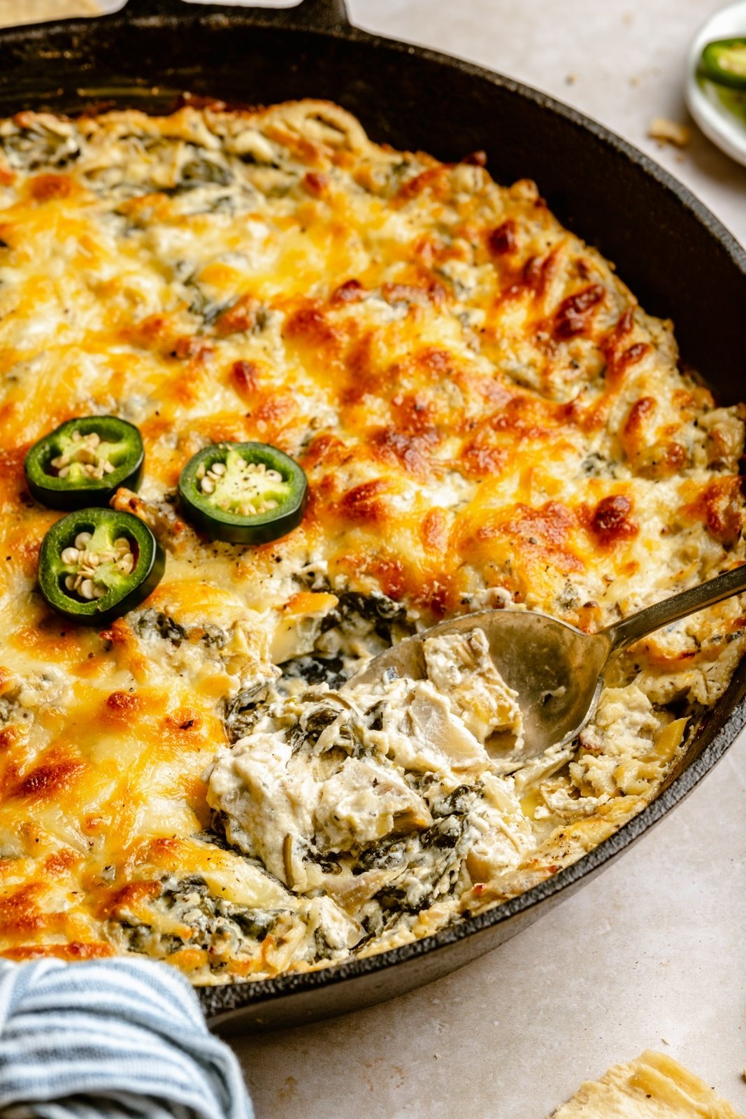 jalapeño spinach and artichoke dip in a skillet with a spoon