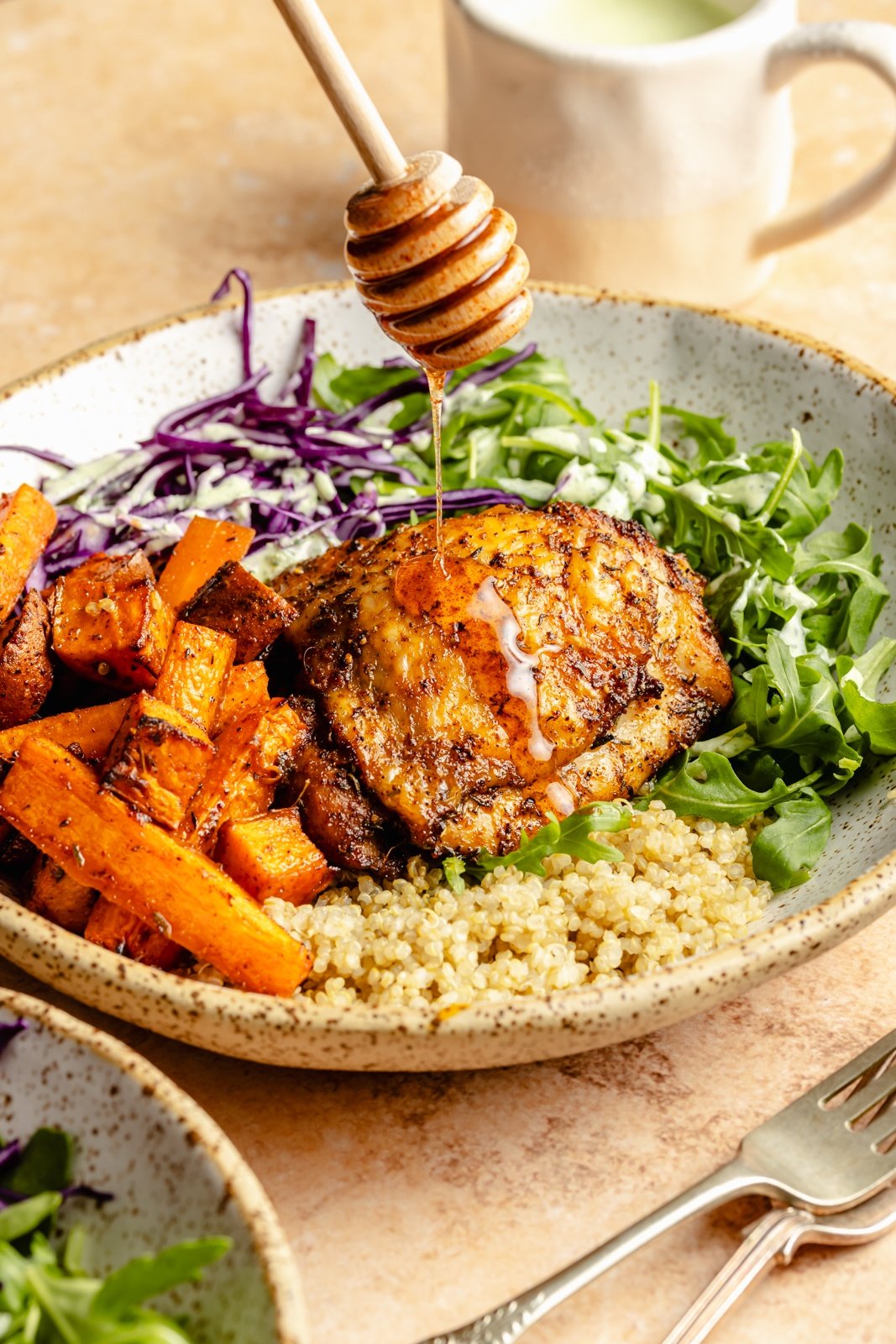 drizzling hot honey onto hot honey chicken bowls with vegetables