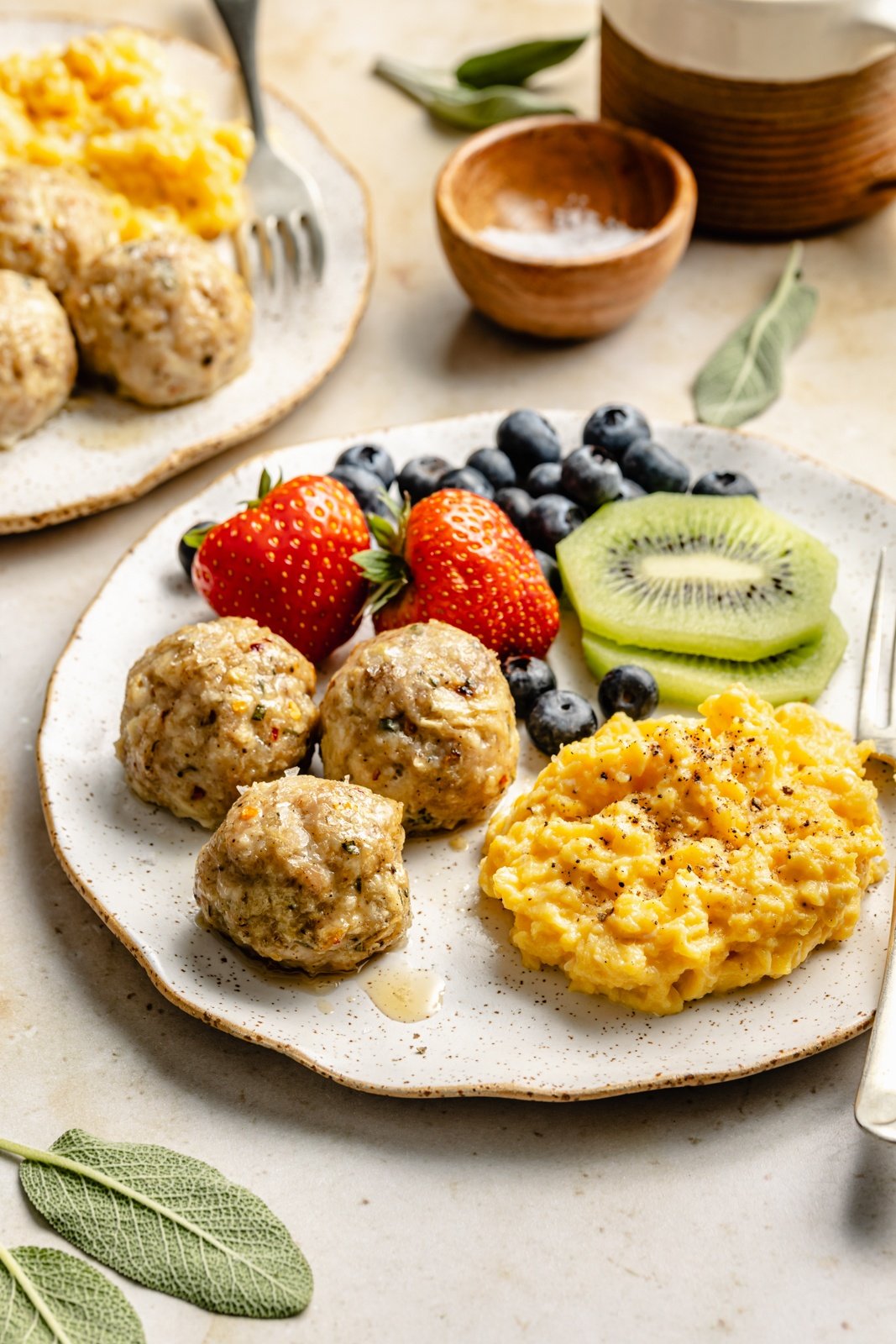 plate of maple chicken breakfast meatballs, fruit, and eggs