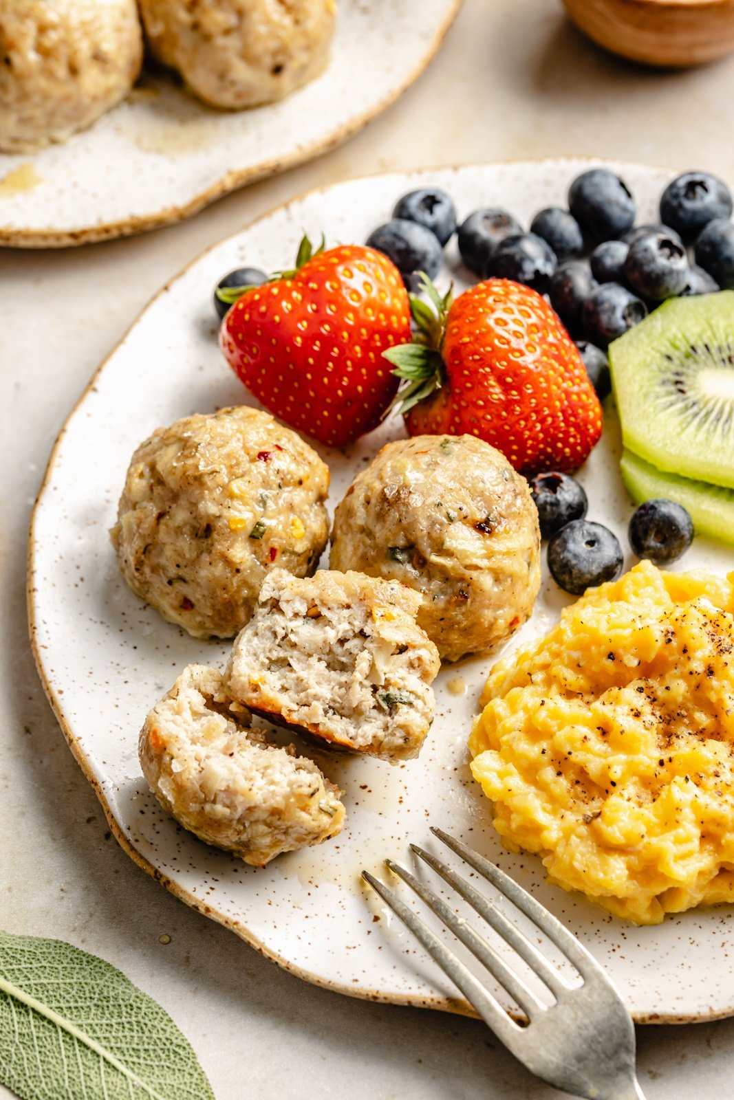 plate of apple chicken meatballs, fruit, and eggs