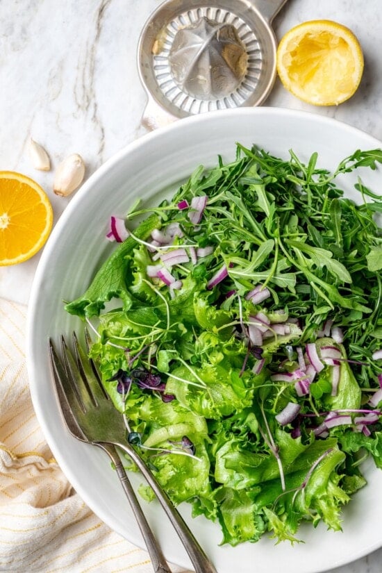 Pan seared scallops taste like a special occasion dinner but they’re easy enough for a weeknight. Serve over salad for a light, healthy meal! Overhead view of salad with red onions