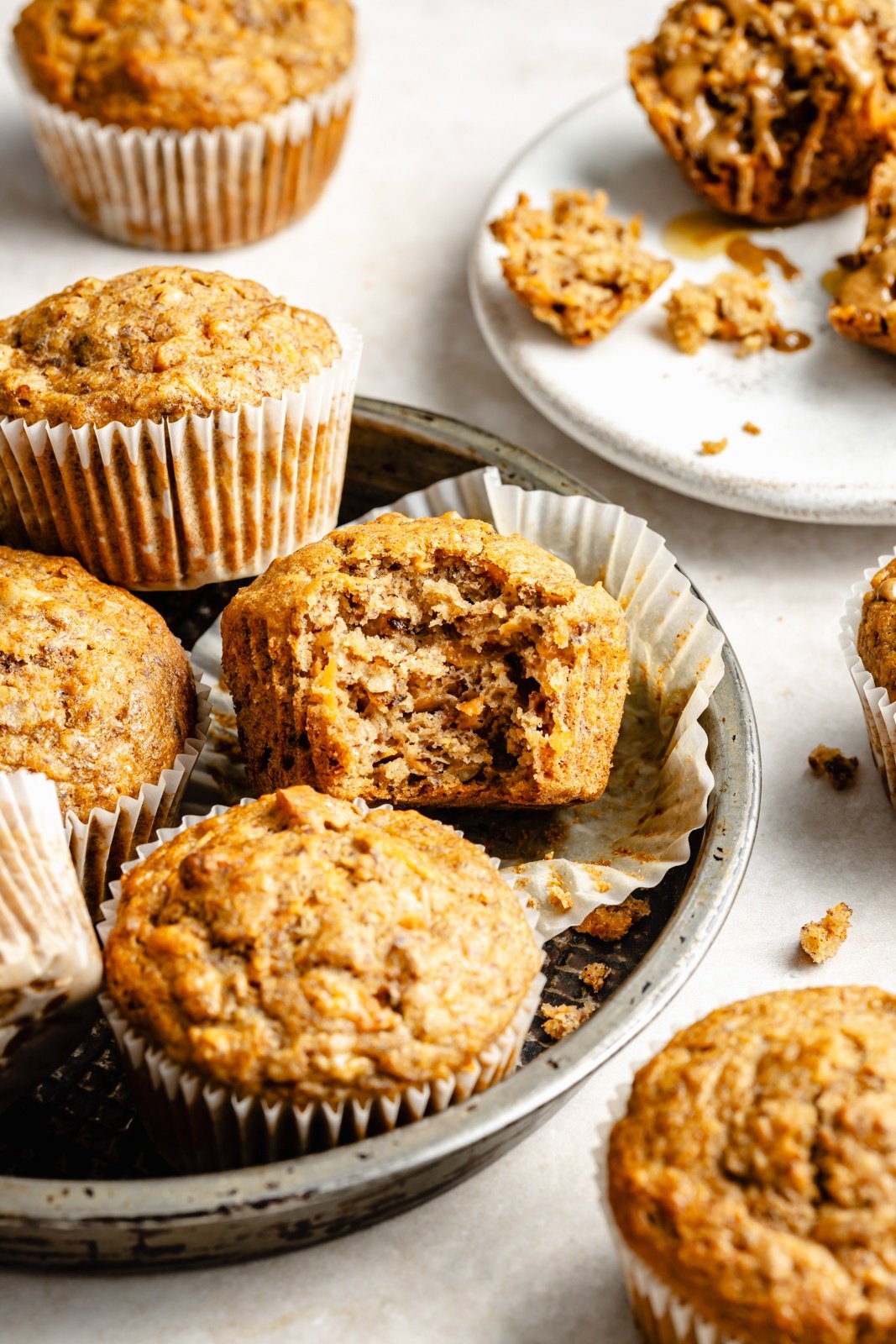 apple banana carrot muffins on a plate with a bite taken out