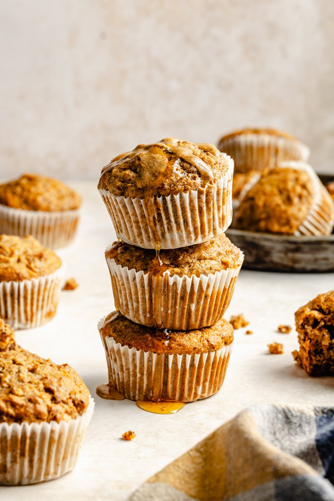 three apple, banana, and carrot muffins in a stack