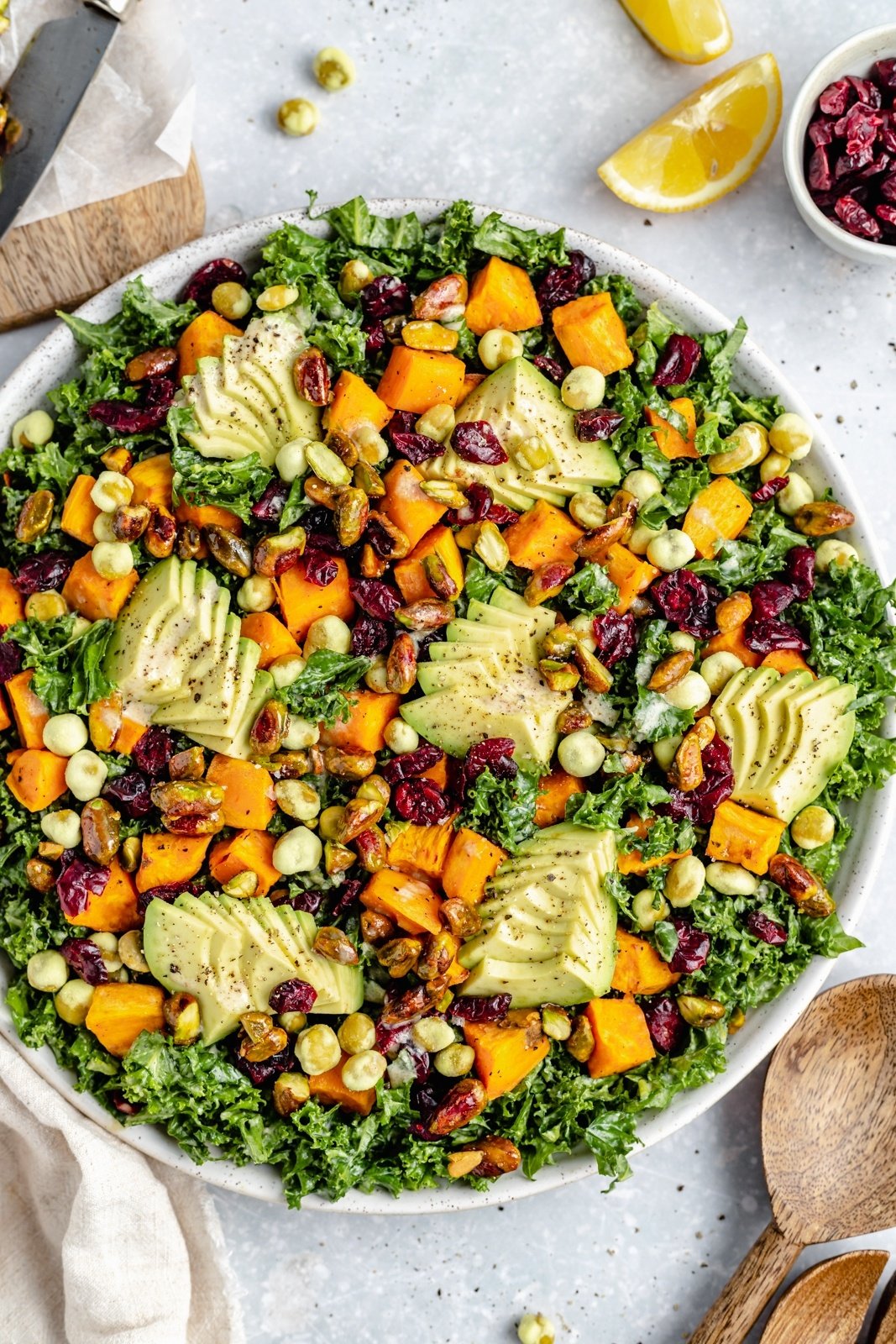 sweet potato kale salad in a bowl topped with avocado