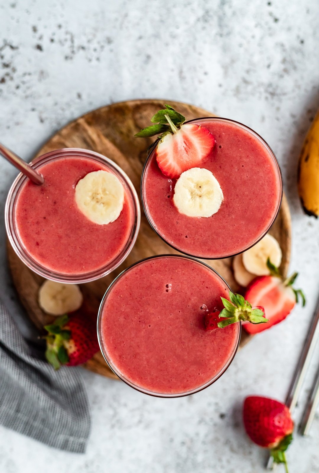 strawberry orange banana smoothie in three glasses