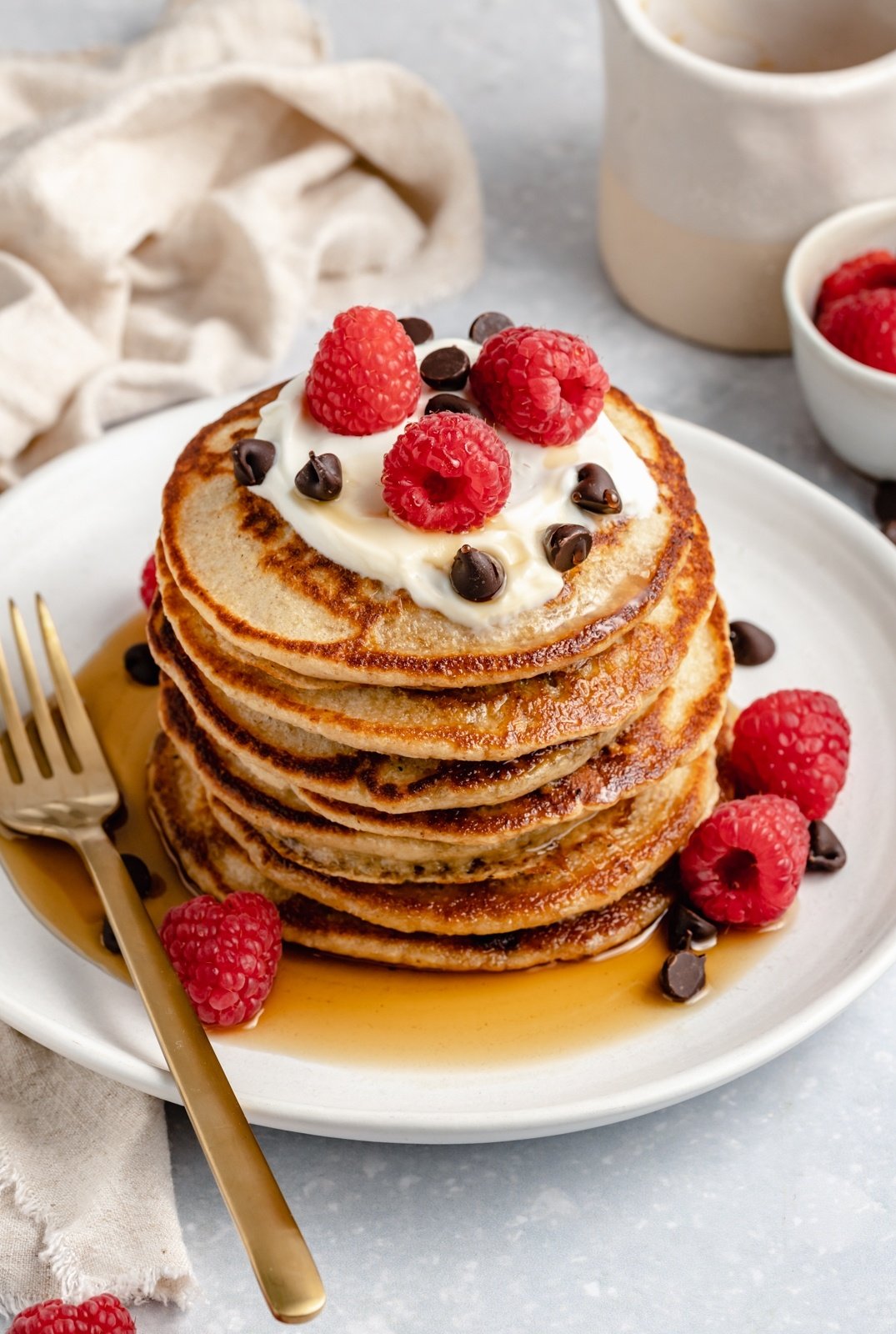 stack of gluten free yogurt pancakes topped with raspberries