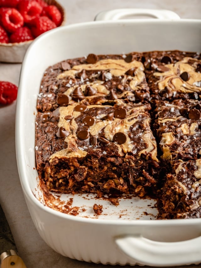 chocolate peanut butter baked oatmeal in a baking dish with a slice cut out