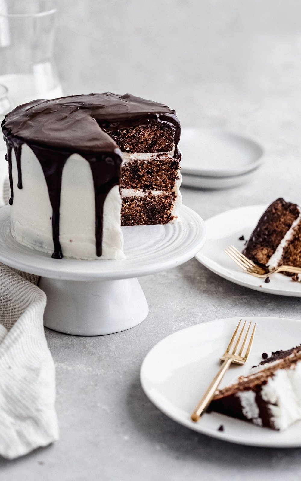 grain free cookie cake on a cake stand with two plated slices of cake