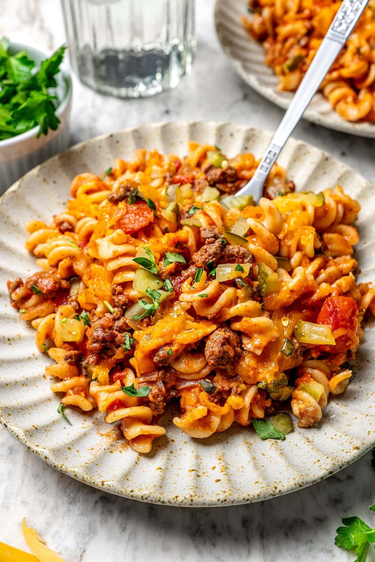 With ground beef, tomatoes, pickles, and cheese, this lightened up cheeseburger casserole recipe is kid-friendly and so delicious! Cheeseburger casserole on plate with fork