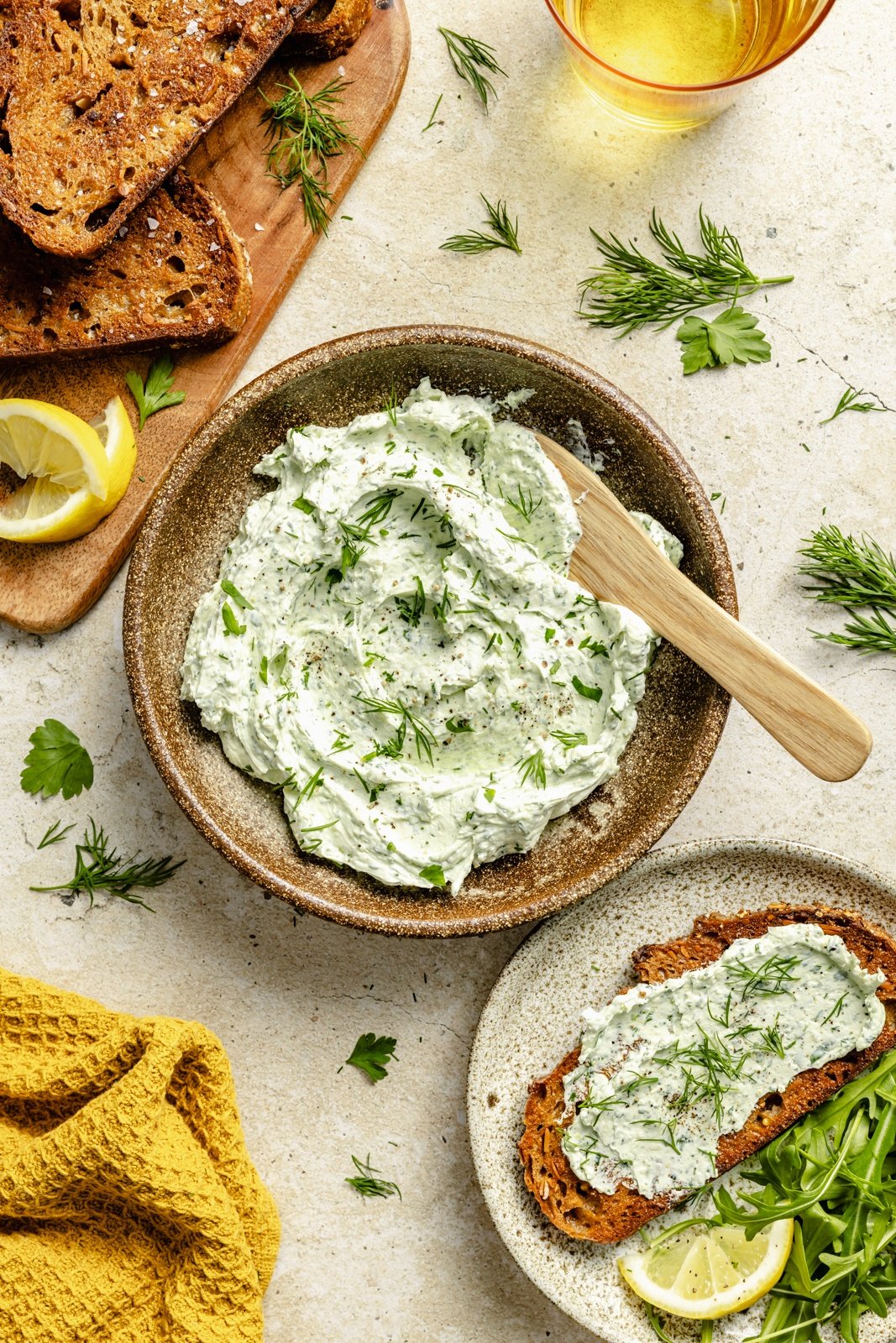 healthy herbed goat cheese dip in a bowl and spread on toast