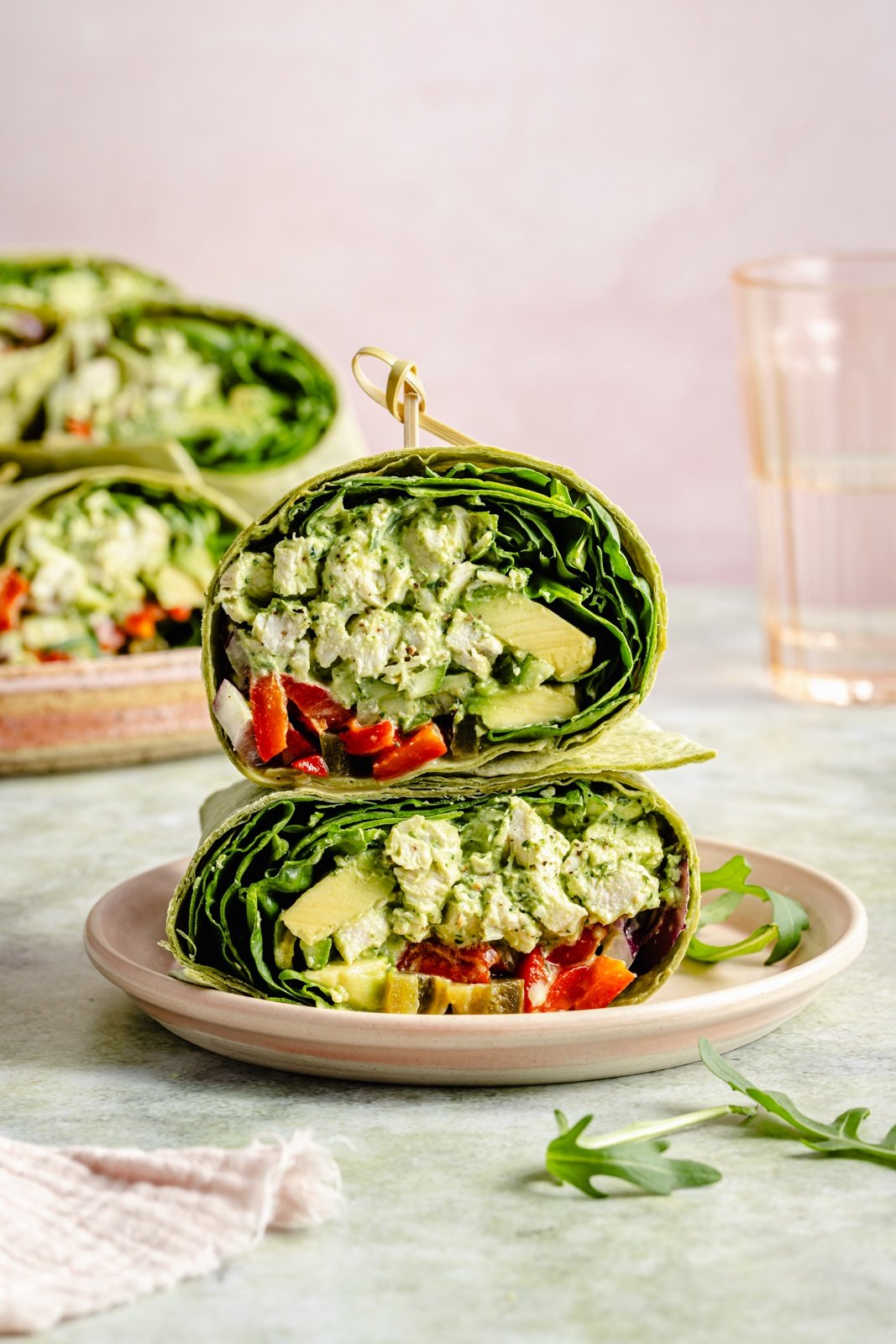 two halves of a green goddess chicken salad wrap stacked on a plate