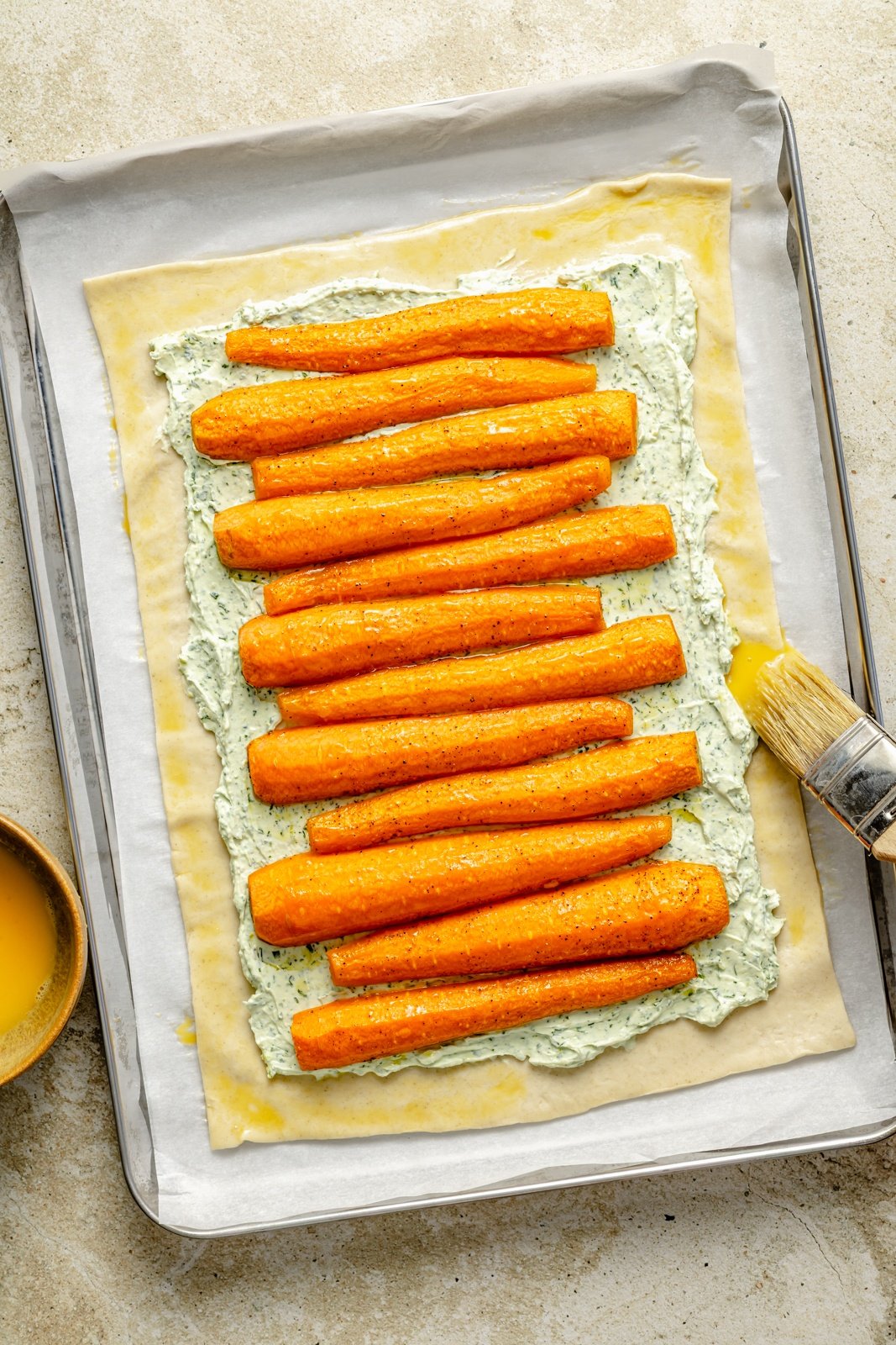 topping puff pastry with roasted carrots to make a roasted carrot tart