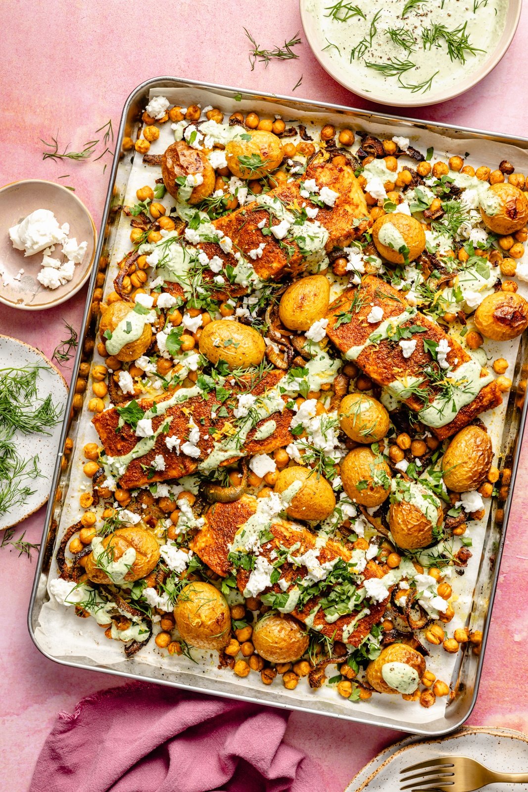 sheet pan salmon with potatoes and chickpeas drizzled with yogurt sauce