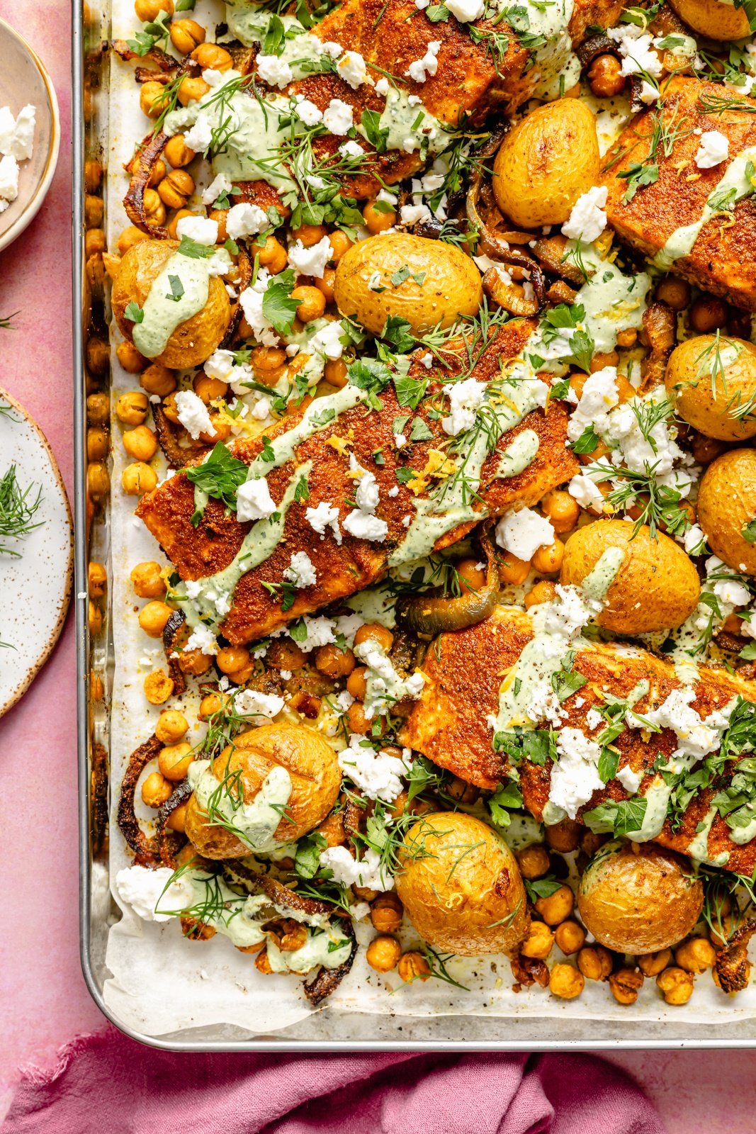 easy sheet pan salmon with potatoes and chickpeas drizzled in sauce